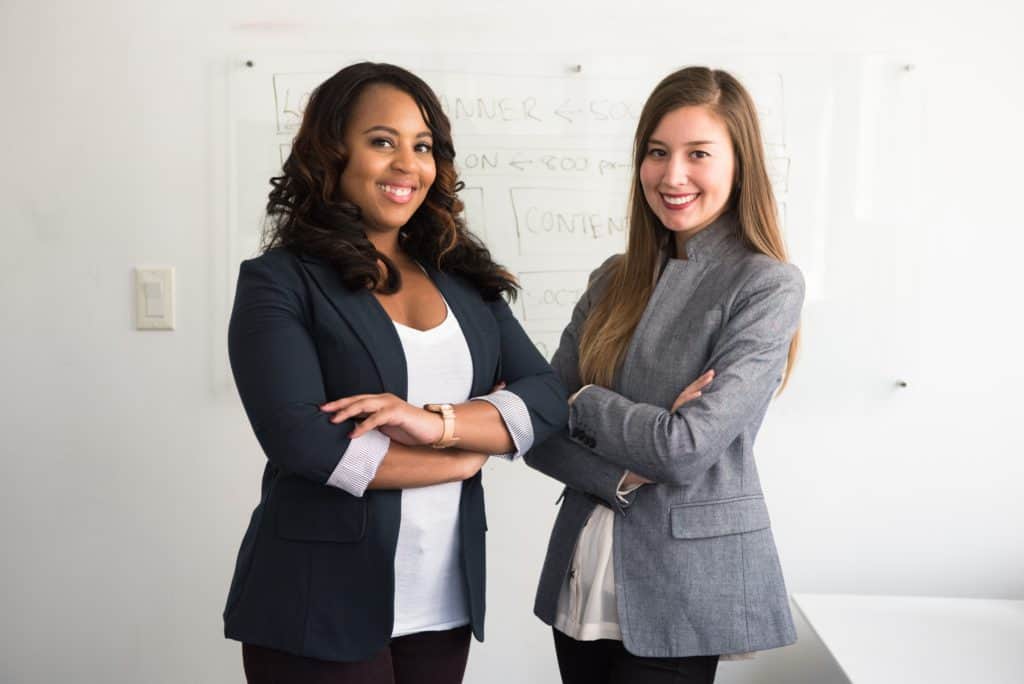business women standing in front of a white board
