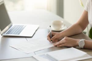 woman signs paperwork